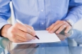 Businessman sitting at desk writing in the office