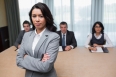 Serious businesswoman standing in front of business panel