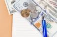 US coins and banknotes with pen on a notebook