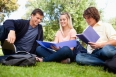 Low angle-shot of three students in a park studying