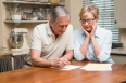 Senior couple working out their bills at home in the kitchen