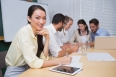 Businesswoman smiling at camera with team behind her in the office