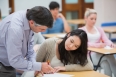 Teacher explaining something to the student in classroom