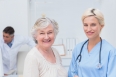 Portrait of nurse and senior patient smiling in clinic