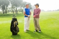 Golfing friends holding clubs at golf course