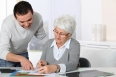 Young man helping elderly woman with paperwork