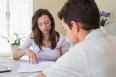 Young woman and man sitting with home bills at the table